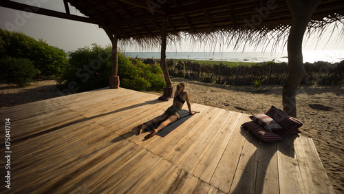 Frau macht Yoga am Meer