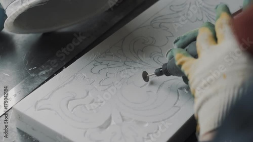 Engraver cut out the pattern in the marble slab, the stencil is applied in advance, making one part of the marble fireplace