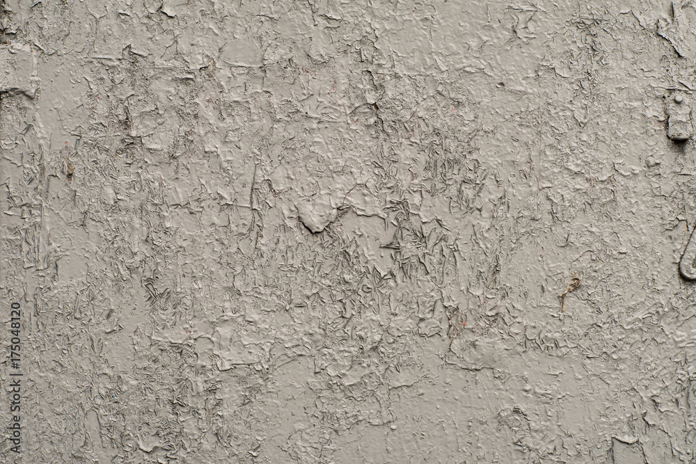 Obraz premium White-gray surface of a wall with cracked paint, plaster, close-up 