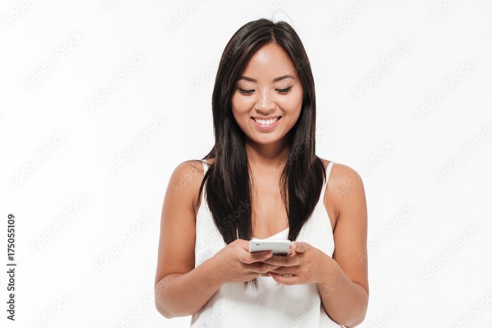 Portrait of a smiling woman standing and using mobile phone Portrait of a smiling woman standing and using mobile phone
