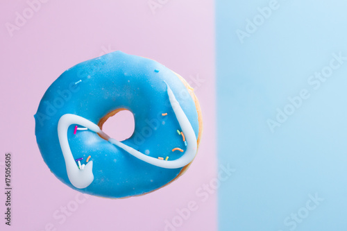 one flying sweet doughnut on blue and pink background