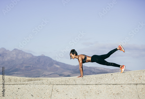 Muscular young woman doing push ups