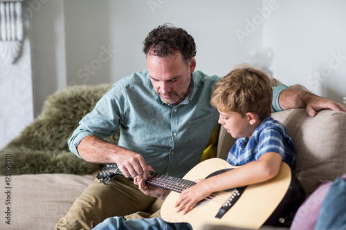 Father teaching son guitar chords photo