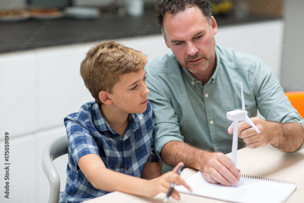 Father helping son with school project Father helping son with school project