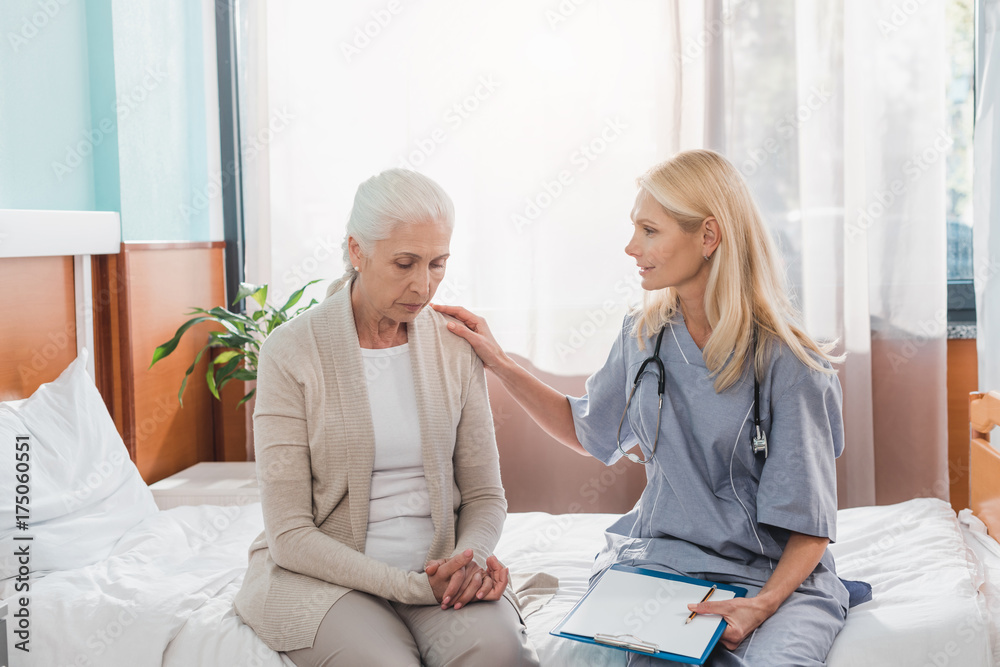 Obraz premium senior woman and nurse with clipboard