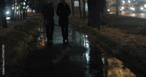 Wallpaper Mural Sidewalk in dark winter city and two women friends walking and having a talk Torontodigital.ca