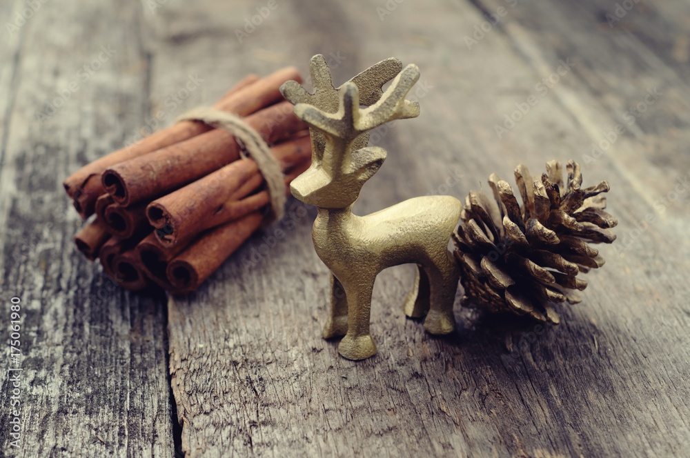 christmas deer cinnamon and cone on wood background