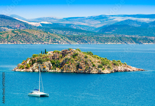 View of the sea on Tolo with a small island and a catamaran