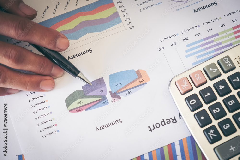 male hands holding a ballpoint and analyzing the financial diagram male hands holding a ballpoint and analyzing the financial diagram