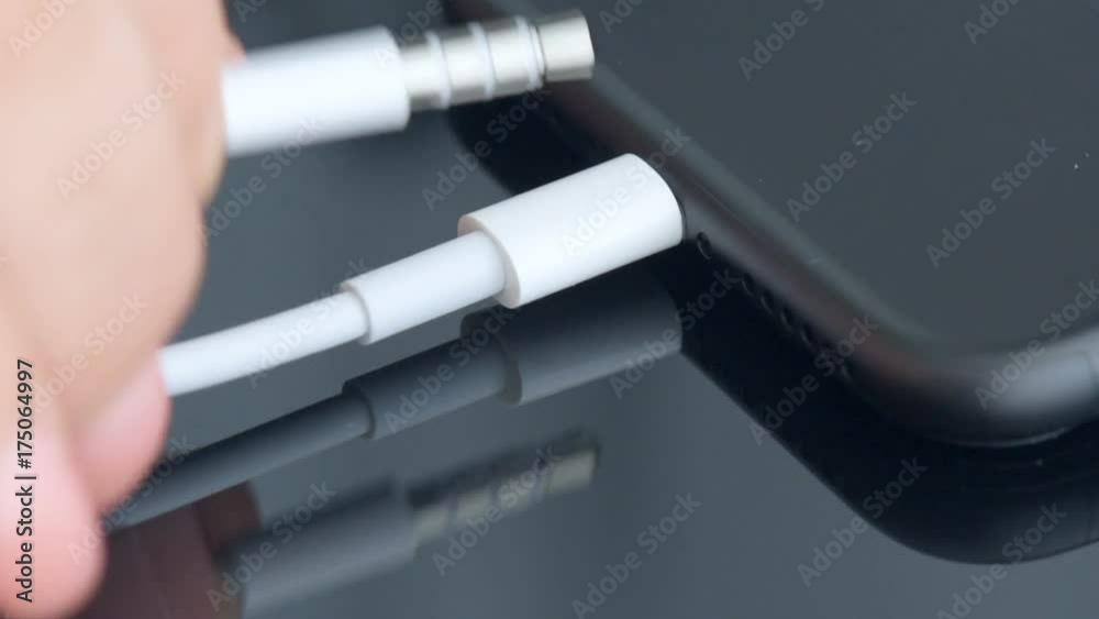 Close up of a mobile phone connected to a charger. Close up of a mobile phone connected to a charger.