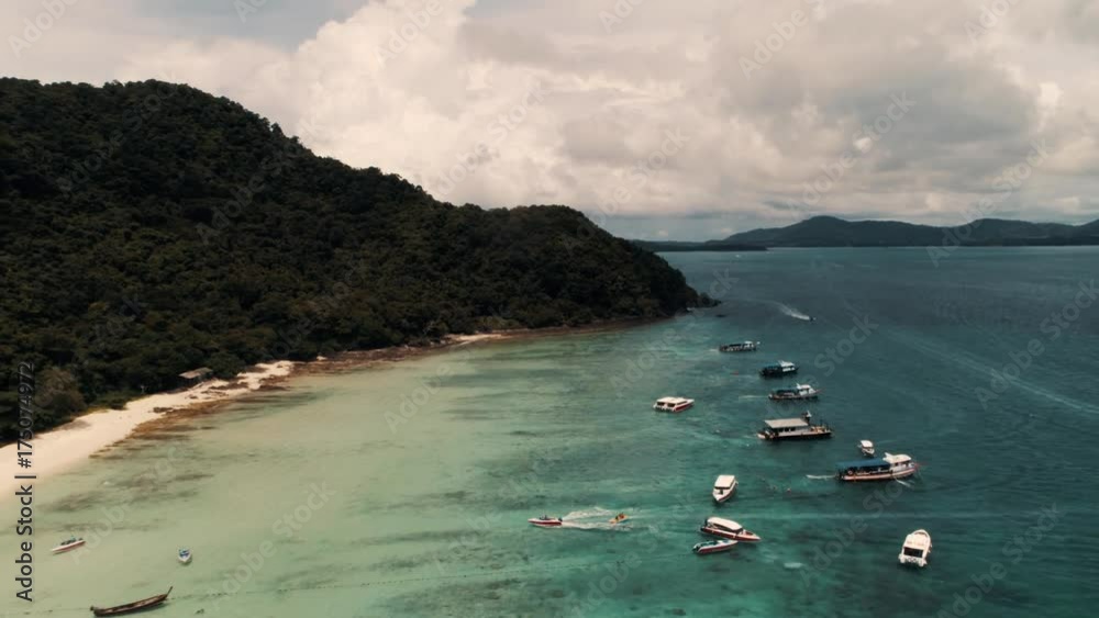 Thailand Coral Island Drone Shot Small sports boats, large catamarans, fishing schooners, active traffic near the island for the entertainment of tourists.