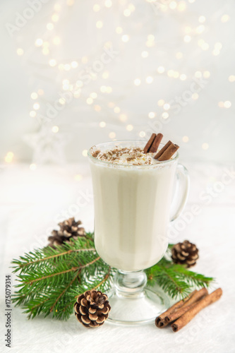 traditional winter eggnog cocktail with whipped cream and cinnamon for Christmas