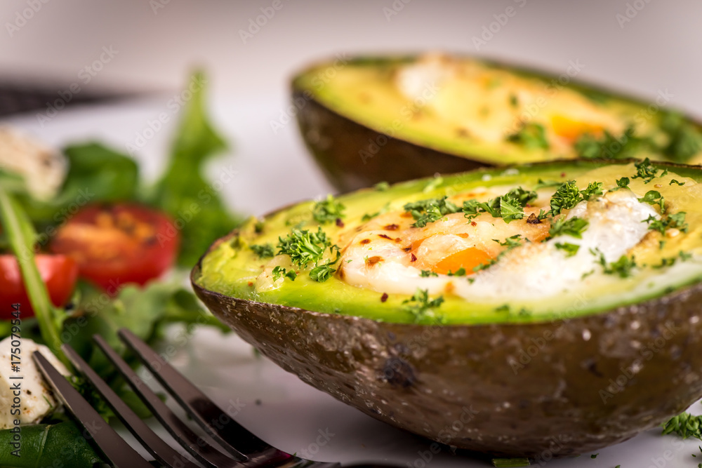 avocado baked with egg and salad with rucola