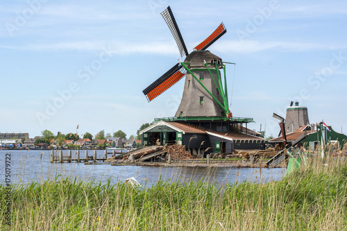 Usual grey mill with orange wings near the water in Zaanse Schans  Netherlands 