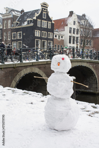 Photography Snowman near the canal and bridge in Amsterdam in winter