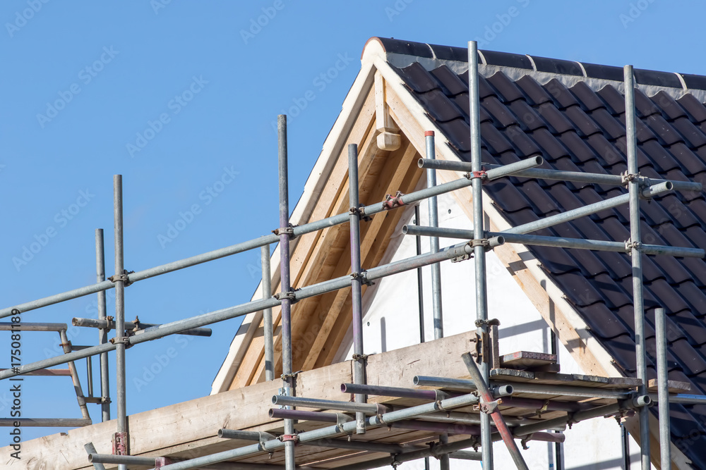 Modern house roof construction with scaffold pole platform