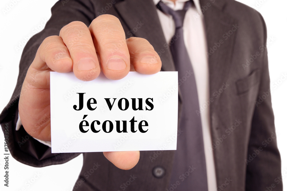 Homme tenant une carte sur laquelle est écrit je vous écoute Homme tenant une carte sur laquelle est écrit je vous écoute