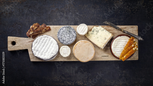 French cheese platter with Spanish dulce de membrillo as top view on a wooden board