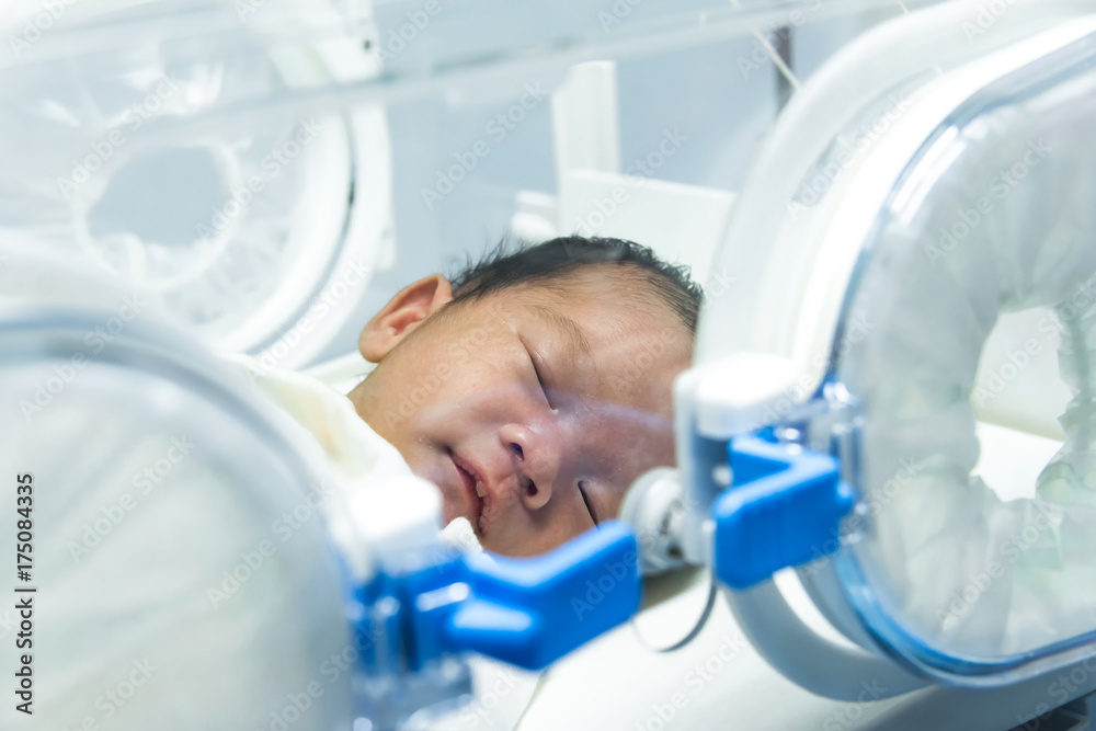 Infant in incubator machine maintain healthy environment for newborn premature sick babies neonatal intensive care unit. Infant in incubator machine maintain healthy environment for newborn premature sick babies neonatal intensive care unit.