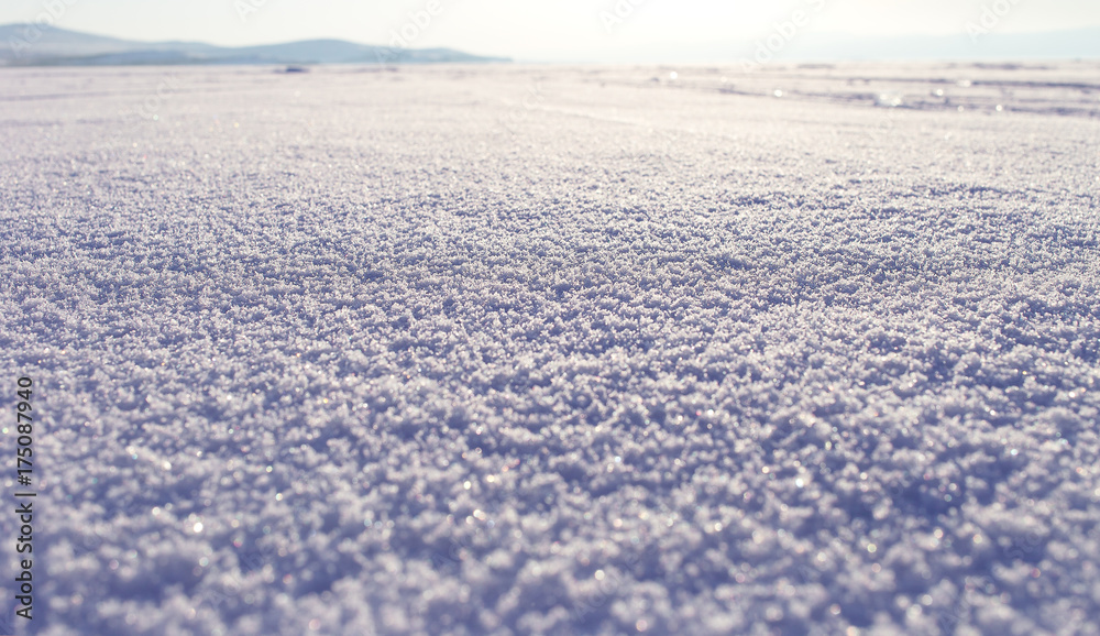 Winter landscape. Snow field sparkling in the sun, surface snow texture. Christmas natural background. Lake Baikal