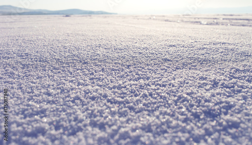 Winter landscape. Snow field sparkling in the sun  surface snow texture. Christmas natural background. Lake Baikal