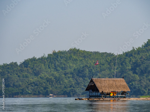 Raft with shelter on the lake restaurant. Lonely raft in focus with mountain blur background. With unidentified people chilling in it.  At Huai Kra Thing, Loei, Thailand photo