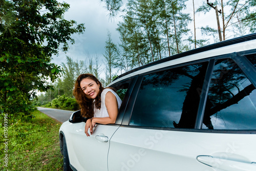 Happy Women tourists looking out the car window on white suv car at roadside in Pine forest, Tropical forest