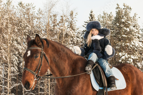 Small girl and horse in a winter © keleny