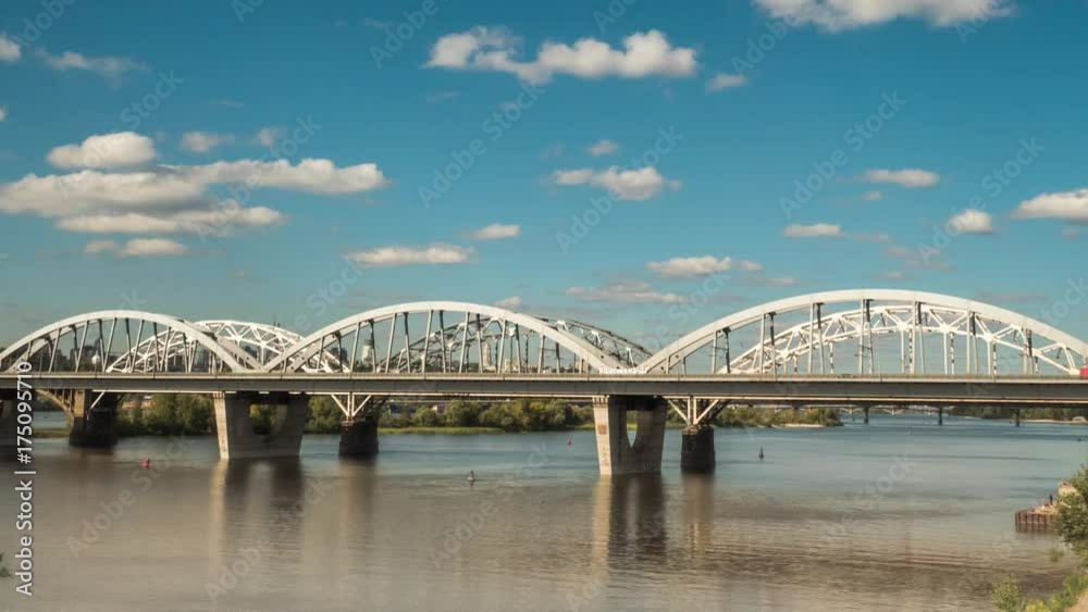 The movement of clouds over the bridge along which cars and trains are moving, a river flows under the bridge, and early autumn has come. pro res 444 The movement of clouds over the bridge along which cars and trains are moving, a river flows under the bridge, and early autumn has come. pro res 444