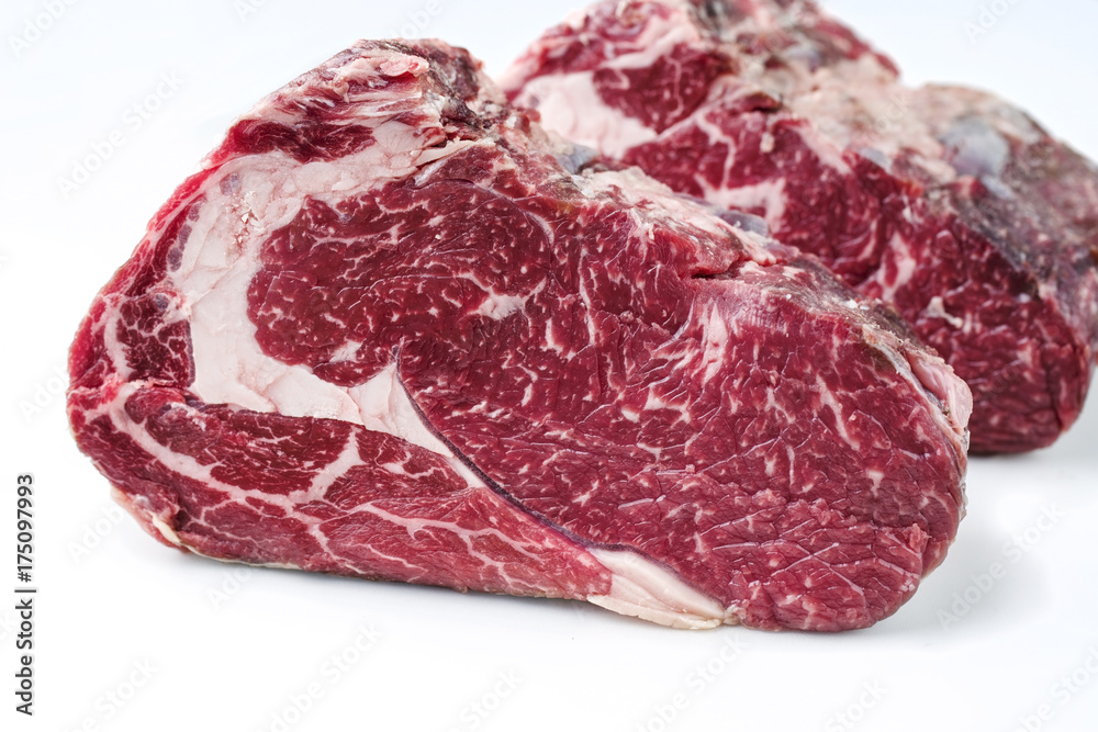 Two raw dry aged Kobe rib eye steak as close-up – covered