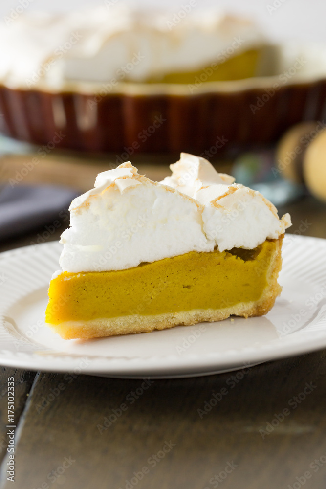 Slice of pumpkin pie with meringue top, vertical close up Slice of pumpkin pie with meringue top, vertical close up