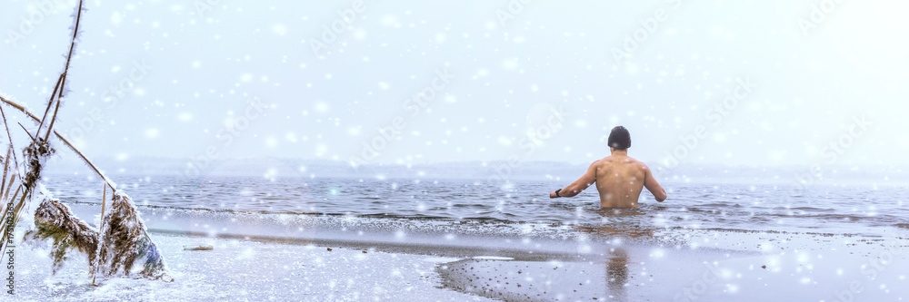 Mann beim Eisbaden im Winter, Panorama mit Schneefall Mann beim Eisbaden im Winter, Panorama mit Schneefall