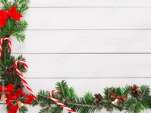 Christmas background with candies and fir tree border on wood