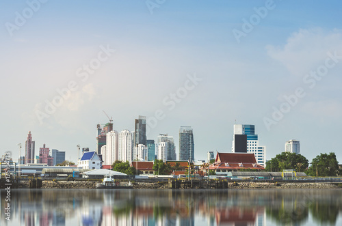 cityscape metropolis outdoor at river side with water reflection and blue sky. the center of the urban residents.