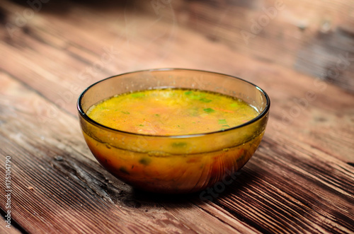 Vegetable soup in a glass bowl on wooden table