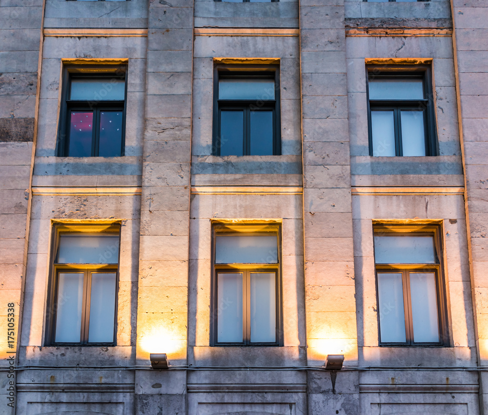 Old town area brick building illuminated by yellow lights and lanterns by street in evening outside in Quebec region city Old town area brick building illuminated by yellow lights and lanterns by street in evening outside in Quebec region city