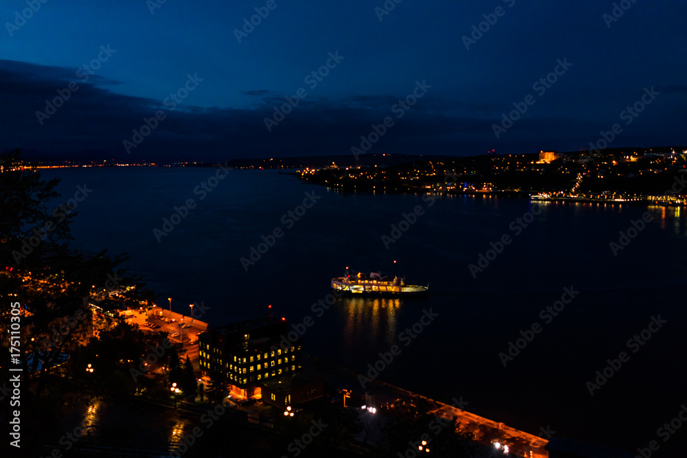 Cityscape or skyline aerial view of Saint Lawrence river and Levis with illuminated ferry at night