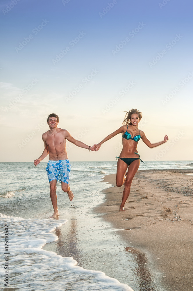 happy couple enjoying vacations on the beach