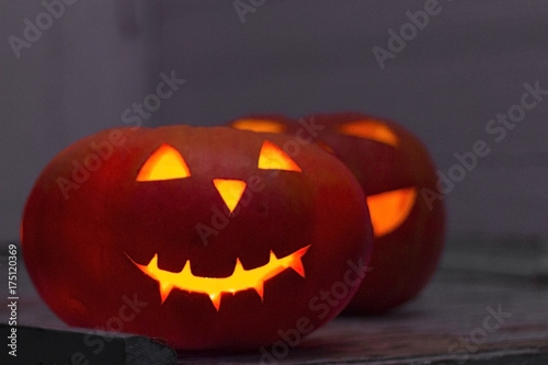 Scary Halloween pumpkins. Scary glowing faces trick or treat. Focus on the front pumpkin