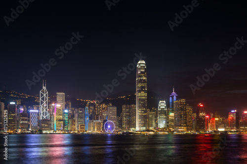 Hong Kong Island's skyline over Victoria Harbour with lit modern skyscrapers at night in Hong Kong, China. Viewed from Tsim Sha Tsui, Kowloon. Copy space. © tuomaslehtinen