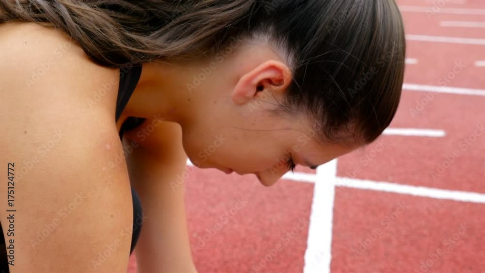 Close detail of track runner putting hands at starting line
