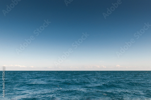 бирюзового цвета море с горизонтом и облаками