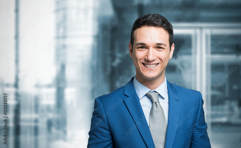 Smiling businessman in front of a blue background Smiling businessman in front of a blue background