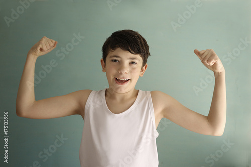 teenager boy in white shirt show biceps smile close up photo photo