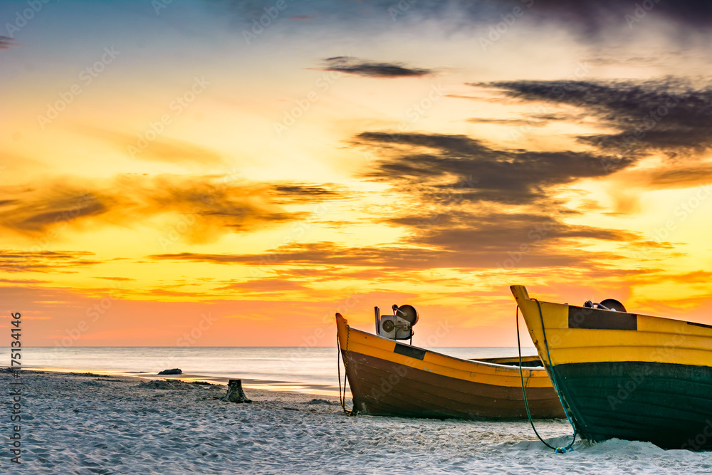 Fishing boats on the sea shore at sunset.