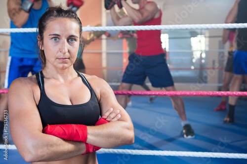 Portrait of confident female boxer standing with arms crossed