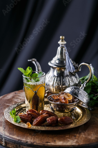 Moroccan tea with mint and sugar in a glass on a dark background