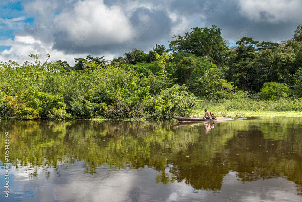 Small canoe moving along the Amazon river Small canoe moving along the Amazon river