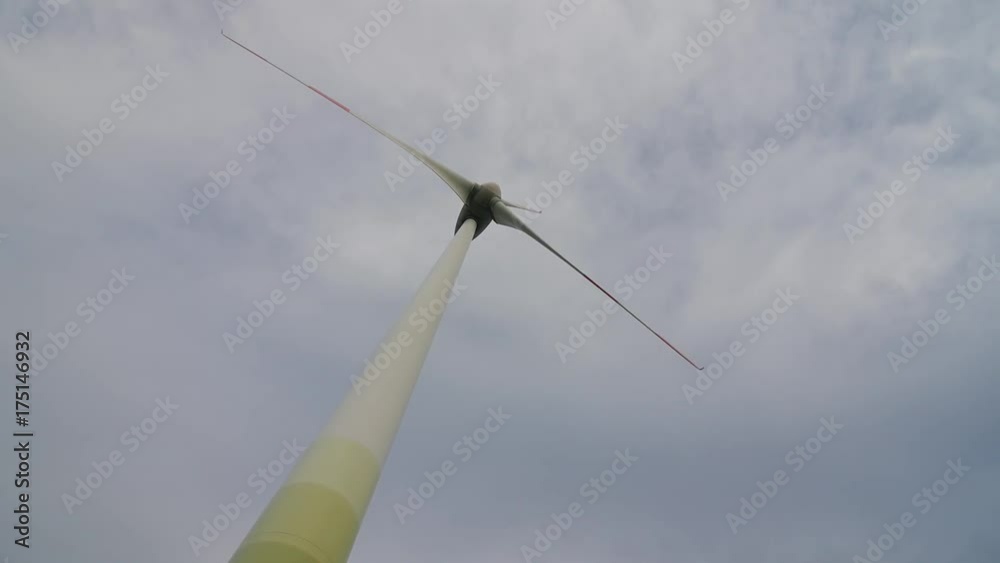 Wind turbine over stormy cloudy sky using renewable energy to generate electrical power. Renewable energy is most environmental way of power generation. Wind turbine over stormy cloudy sky using renewable energy to generate electrical power. Renewable energy is most environmental way of power generation.