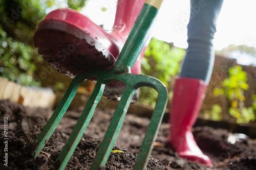 Foto Close-up low section of woman wearing pink rubber boot standing